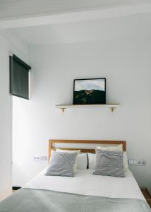 圣塞瓦斯蒂安Guest House Ibaia Et Arramak的卧室配有白色的床和2个枕头