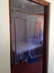 南塔拉拉天堂海滩旅馆的一张小床,在房间里设有天蓬