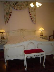 雷克雅未克凤凰酒店的卧室内的白色床和红色长凳