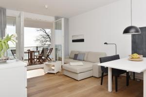 萨斯尼茨Penthouse Ostseeresidenz的白色的客厅配有桌子和沙发