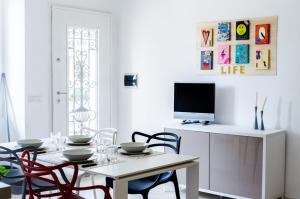 罗马圣塔瑞丽公寓的一间带桌椅和电视的用餐室