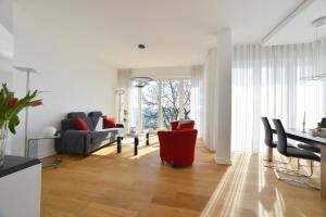 萨斯尼茨Suite Meersinn的客厅配有红色椅子和桌子