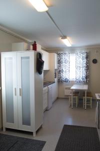 基尔匹斯扎我维哈亭马酒店的厨房配有白色冰箱和桌子