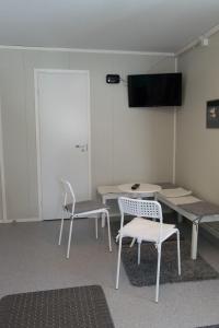 基尔匹斯扎我维哈亭马酒店的一间设有两把椅子、一张桌子和一台电视的房间