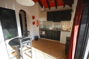 塔维拉Pedras D'el Rei Villa V1的厨房配有黑色橱柜和桌子