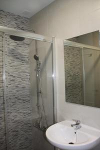 科尼尔-德拉弗龙特拉Apartamentos El Yunque- Solo Familias的浴室配有盥洗盆和带镜子的淋浴
