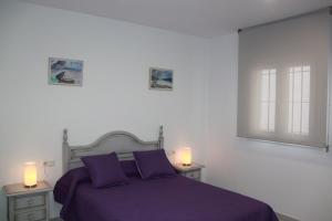 科尼尔-德拉弗龙特拉Apartamentos El Yunque- Solo Familias的一间卧室配有一张带2晚台的紫色床
