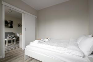 华沙Apartament Centrum Żurawia的白色卧室配有一张带白色床单的大床