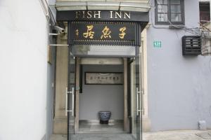 上海上海子鱼居外滩店的一座建筑的入口,上面有鱼旅馆标志