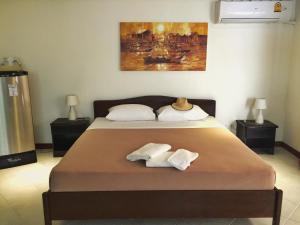 芭东海滩蓝天公寓式酒店的一间卧室配有一张床,上面有两条毛巾
