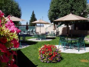 米苏拉百老汇酒店会议中心 的花园设有桌椅、遮阳伞和鲜花