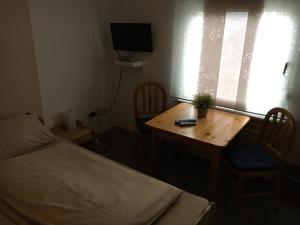 维尔恩斯多夫德累艾臣宾馆的一间卧室配有一张床和一张桌子,上面有植物
