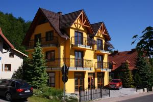 卡尔帕奇DARIA pokoje gościnne的黄色建筑,有黑色屋顶