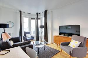 巴黎Pick A Flat's Apartments in Saint Michel - Rue Du Sommerard的客厅配有沙发、椅子和电视