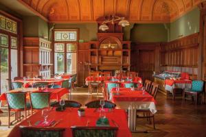 比亚里茨VTF Le Domaine de Françon的一间设有红色桌椅的用餐室