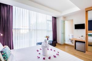 曼谷Solo Express Sukhumvit 81的一间酒店客房,床上摆放着鲜花