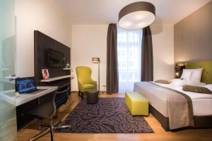 波恩列诺努集团酒店的酒店客房配有一张床、一张书桌和一台电脑