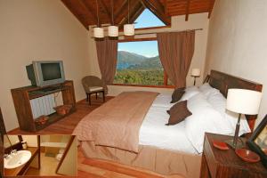 圣卡洛斯-德巴里洛切埃斯坦西亚德尔卡门山度假酒店的一间卧室设有一张大床和一个窗户。