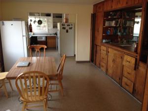 安克雷奇Base Camp Anchorage Hostel的厨房配有桌椅和冰箱。