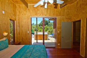 拉罗汤加拉罗汤加天堂假日别墅的卧室配有1张床,享有浴缸的景致