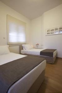 Gonia宜家豪华公寓的一间卧室设有两张床,其中设有窗户。