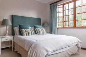 约翰内斯堡Sandown Estate Apartment的卧室设有一张白色大床和一扇窗户。