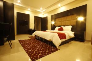 布赖代Manazel Al Hamra Apartment 2的一间卧室配有一张大床和红色地毯。