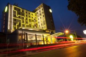 泗水耶穆尔萨利黄釉酒店 的街道前有 ⁇ 虹灯的建筑