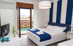 索伦托索伦托海洋客房旅馆的一间卧室配有一张蓝色和白色条纹的床