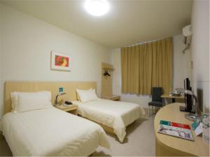 泰安锦江之星泰安泰山大街店的酒店客房配有两张床和一张书桌