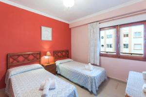 莫莱拉Sirena的宿舍间的两张床,设有红色的墙壁和窗户。