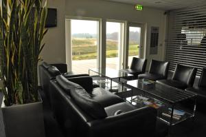 BankerydSand Golf Club的客厅配有黑色真皮座椅和桌子