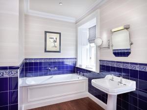 爱丁堡Hapimag Resort Edinburgh的蓝色瓷砖浴室设有浴缸和水槽