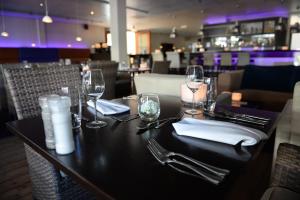 德科赫库艮弗莱彻餐厅酒店 的餐厅的桌子,带眼镜和餐巾