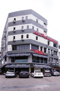 瓜拉丁加奴Asia Premium Hotel Kuala Terengganu的停车场内停放汽车的大型建筑