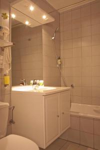布利安什维莱温泽博格酒店的一间带水槽、浴缸和卫生间的浴室