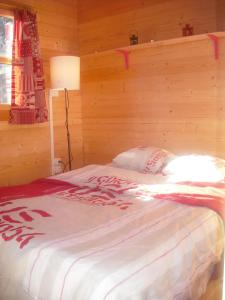 米茹蒙茨朱拉木屋的一间卧室设有一张带木墙的大床