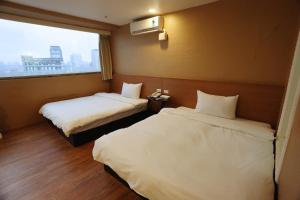台北板桥王旅馆的酒店客房设有两张床和窗户。