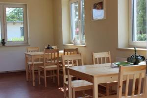 MechelsdorfOstseepension TonArt的用餐室设有木桌、椅子和窗户。