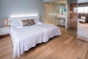 坎布里尔斯Mònica Hotel的一间带白色大床的卧室和一间浴室