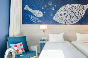 康斯坦茨康斯坦茨宜必思尚品酒店的酒店客房,配有一张床和一张蓝色椅子