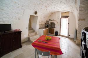 奥斯图尼Borgovecchio Suite的厨房里设有一张桌子,上面有红色布料