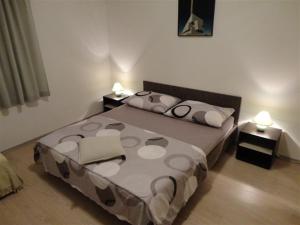 皮罗瓦茨Apartments Sljuka的一间卧室配有一张带两张桌子和两盏灯的床。