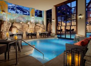提顿村蛇河别墅温泉罗克度假酒店的度假村内的大型游泳池,配有桌椅