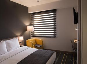 埃里温埃里温新星酒店的卧室配有床、椅子和窗户。