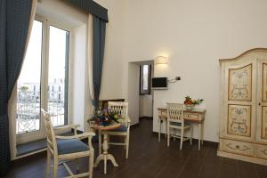 巴科利La Rada B&B的客厅配有桌椅和窗户。