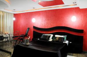圣保罗Floresta Tucuruvi (Adult Only)的一间卧室设有一张床和红色的墙壁