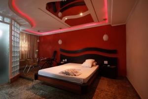 圣保罗Floresta Tucuruvi (Adult Only)的一间卧室配有一张红色墙壁的床