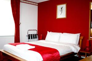 滨海绍森德Ilfracombe House Hotel - near Cliffs Pavilion的红色的卧室,配有一张红色墙壁的床