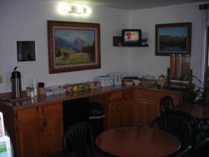 科尔特斯Cozy Inn的厨房配有木制橱柜和桌椅